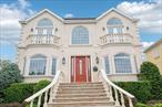 Grand and Palatial in Woodmere! Step into this newly renovated 3-story stucco Colonial that combines elegance, space, and comfort. A dramatic two story  entry foyer sets the tone for this extraordinary residence featuring 6 bedrooms and 4 full bathrooms. The home boasts a formal living room banquet-sized dining room, and a chefs eat-in kitchen with high- end appliances and abundant cabinetry-perfect for entertaining. A den, library provides a quiet retreat, while a Juliet balcony and spacious deck extend the  living space outdoors. Modern conveniences include 4 zone heating, thoughtful updates throughout and a layout designed for both grand gatherings and everyday living