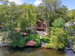 This 4-bedroom, 3-bathroom contemporary lakefront in Emerald provides over 2, 500 sq ft of light-filled living space on shoreline of Lake Louise Marie. 81 feet of lake frontage with its own private dock, the property delivers panoramic water views. Soaring vaulted ceilings and floor-to-ceiling windows on the main level flood the interior with natural light, showcasing the open living and dining area and framing stunning lake vistas. A propane fireplace on the main floor adds warmth and ambiance on cool late summer evenings. The main level also includes two bedrooms and a full bath, offering the option for convenient single-level living.Upstairs, the private primary suite occupies its own floor, featuring a walk-in closet, an en-suite bathroom, and a private balcony overlooking the lake. This lofty perch is perfect for morning coffee or stargazing over the water.The finished walkout basement expands your living space with a second family/recreation room, a wood-burning fireplace, a fourth bedroom, and a full bathroom. This level opens directly to the lakefront, making it easy for swimmers to come inside and towel off after a dip. With its own entrance and full bath, the lower level works perfectly as private guest quarters or a fun recreation area by the water. A second laundry room on this floor adds convenience, complementing the main-floor laundry setup.New sod lawn & sprinkler system (2025): Enjoy a lush green yard with easy maintenance (sprinklers installed).Custom patio lighting, stonework and firepit! Newly installed lighting illuminates the property for evening gatherings, and upgraded stonework (with selective tree removal) enhances the landscape and lake views.The bathrooms have been updated with new vanities and mirrors for a clean, contemporary look.Two fireplaces: Propane fireplace upstairs and wood-burning fireplace downstairs provide warmth and ambiance on each level.Dual laundry areas: Laundry facilities on both the main floor and in the walkout basement offer ultimate convenience.Two-car attached garage: An attached 2-car garage provides secure parking and extra storage space.Storage shed: A large shed (2020) offers additional storage for lawn equipment, lake gear, and seasonal items.Outside, a spacious deck and patio overlook the lake, offering plenty of space for outdoor dining and relaxation. The gently sloping yard leads to your private dock on Lake Louise Marie, where you can enjoy boating, fishing, or simply soaking in panoramic water views. The lake permits electric boats only, preserving the peaceful environment for kayaks, paddleboards, and swimmers. Thanks to the new lawn, sprinkler system, and thoughtful landscaping improvements, the grounds are as low-maintenance as they are beautiful.Located in the desirable Emerald Green community, this home grants you access to a host of private amenities. Members enjoy a clubhouse, a swimming pool, tennis and pickleball courts, a fitness center, a beach, and lake access for swimming and boating (electric motors only). All of this is just under two hours from New York City, offering the perfect balance of a peaceful lakefront setting and convenient access to the city and local shopping and eateries. 116 Lake Shore Drive West offers a perfect blend of modern comfort, natural beauty, and resort-style living.
