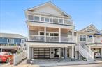 This spacious and beautifully appointed 4-bedroom, 3-bath home was completely custom-designed and professionally decorated, offering a perfect blend of beachside sophistication and everyday comfort.The main level features a generously sized open-concept layout with a large gourmet kitchen that flows seamlessly into an expansive dining and living area â€” ideal for entertaining. Oversized sliders lead to a spacious covered deck, extending the living space outdoors. A large bedroom, full bath, and radiant heated tiled floors complete this level.Upstairs, the enormous primary suite features vaulted ceilings, a walk-in closet, and a private, oversized deck with both ocean and bay views. Two additional generously sized bedrooms, another full bath, laundry area, and beautiful hardwood floors make the upper level as functional as it is comfortable.Additional features include custom closets and window treatments, TimberTech decking, a heated two-car tandem garage with interior access, additional driveway parking for two more vehicles, an outdoor shower, LED lighting, two-zone central air conditioning, and three-zone heating.Located on a wide block in the West End just moments from the beach, boardwalk, shops, dining, and the Long Island Rail Road â€” offering a true combination of luxury, size, and lifestyle. This home is a standout example of Long Beach living at its finest.