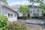Impeccably maintained and artfully styled, this four-bedroom, three-and-a-half-bath French Country Colonial marries refined elegance with effortless modern living. Step through the double front doors into a dramatic two-story foyer, where rich hardwood floors and graceful millwork introduce interiors that flow seamlessly from room to room. At the homeâ€™s heart, an open-concept coreâ€”living room with gas fireplace, formal dining room, window-wrapped sunroom, and sophisticated built-in barâ€”creates an entertainerâ€™s playground as welcoming for quiet cocktails as it is for festive holiday gatherings. Everyday life centers around the chefâ€™s eat-in kitchen and a vaulted family room anchored by a floor-to-ceiling, wood burning stone fireplace. French doors blur the line between indoors and out, leading to custom-designed patios framed by pergola, specimen trees, vibrant flowerbeds, and low garden wallsâ€”an idyllic backdrop for alfresco dinners or lazy weekend mornings. A thoughtfully designed mudroom corrals gear and groceries and offers direct access to a private guest or au-pair suite over the garage, complete with its own bedroom and full bath. Upstairs, the serene primary suite pampers with a fireside (gas) sitting area flanked by built-ins and a spa-inspired bath featuring a deep soaking tub, glass-enclosed shower, and dual vanities. Two additional family bedrooms are bright, well-proportioned, and served by a pristine hall bath. The finished lower level (finished storage)easily flexes as a playroom, gym, or media lounge while still providing abundant storage. With its designer touches, manicured grounds, and a layout that balances day-to-day comfort with show-stopping entertaining, this turnkey residence promises a lifestyle of effortless eleganceâ€”simply move in and enjoy.