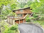 Wesley Hills! What a find! Stunning mid-century modern 4â€“5 bedroom home set on a wooded property offering privacy and serene views. This residence has been meticulously maintained with only the finest finishes and fixtures throughout.The heart of the home is a high-end modern kitchen by Executive Cabinetry, Greengard Gold certified, featuring stainless steel appliances including a Sub-Zero refrigerator and custom Ann Sacks tile backsplash. Walls of glass bring the outdoors in, complete with custom window treatments and a motorized shade for the dramatic palladium window. Hardwood floors flow throughout the upper level, while floating stairs accent the striking two-story entry.The lower level is bright and inviting, offering a spacious great room and office/bedroom. Additional highlights include: irrigation system, water softener, gas fireplace with reclaimed wood mantle, and built-in closets. Recent upgrades: 3-year-old roof, 2-year-old driveway, new Belgian block curbs, and a high-efficiency direct-vent Utica boiler.Enjoy outdoor living on the patio outside the dining area from Marvin sliding glass doors or the porch above the oversized 12&rsquo; Ã— 26&rsquo; two-car garage. Designer touches abound with Murano glass and alabaster sconces. This special home combines a rustic feel, luxury, and tons of privacy.