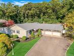 Welcome to 39 Robinhood Lane in East Setauket. This 3-bedroom, 2-full-bath ranch offers comfort, functionality, and generous space. Inside, brand-new hardwood floors extend throughout the main living areas, creating a clean and updated look. The primary bedroom includes a full en suite bath for convenience and privacy. The kitchen is equipped with stainless steel appliances, providing a modern and efficient cooking area. A den with an indoor wood-burning fireplace adds warmth and a cozy gathering space. A full basement with egress windows offers excellent potential for future finishing, adding flexibility for additional living space or storage.The property features a wide, expansive driveway and an oversized 2-car garage, providing ample parking and storage options. Outdoor amenities include an expansive in-ground pool with secure fencing, a built-in paver fire pit, and two storage sheds for added functionality. A sunroom located off the back of the home offers additional space for seasonal enjoyment and views of the backyard.Situated on approximately .52 acres, this property backs to wooded land, creating a private and peaceful setting. With its combination of interior updates, desirable outdoor features, and generous lot size, this ranch-style home provides exceptional potential for its next owner.