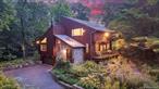 Modern convenience meets the tranquility of nature in this mid-century inspired retreat. Set on 1.04 acres, this 3, 160 SF contemporary home blends privacy, clean lines, and seamless indoor-outdoor living. Expansive Marvin windows, vaulted ceilings with skylights, exposed beams, and a sunken living room connect every space to the outdoors. Multiple decks invite you to read, bird watch, or simply soak in the serene landscape. The chefâ€™s kitchen with granite waterfall island, mahogany counters, stainless Thermador appliances, and double ovens flows to the dining room and large slate patio overlooking meadows, rock walls, and mature trees. Hardwood floors, mahogany siding and a wood-burning stove add warmth and character. Upstairs offers four bedrooms including a primary suite with private bath and balcony, plus a large playroom/4th bedroom, laundry, and a full walk-up attic with potential for expansion. Lush pollinator gardens, lower lawn, and versatile outbuildings - garden sheds, and storage - enhance a sustainable lifestyle. Additional highlights include an ADT alarm/fire system, generator hook-up, plenty of storage and a two-car garage. Minutes from town, highways, and a 30-minute train to Grand Central, this property offers modern living in harmony with nature.