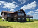 Secluded Hilltop Retreat with Spectacular Views & Endless Potential! Perched atop a hill with panoramic mountain views in every direction, this 2900 Sq ft, 2+ bed, 2.5-bath LOG home with flexible space offers peace, privacy, and charm. Set on 8.5 acres with a private drive, stone walls this one-of-a-kind property is ideal as a full-time residence, weekend escape, or rental investment. Inside, the open-concept great room features vaulted ceilings, skylights, and a wall of windows that flood the space with natural light and frame the breathtaking views. A pellet stove and radiant-heated tile floors provide year-round comfort. The kitchen has stainless appliances and a center island with seating opening up to the bright dining area with walk out to the expansive wraparound deckâ€”perfect for outdoor dining or simply soaking in the scenery. The main level also offers a spacious primary suite with walk-in closet and full bath, a mudroom, a pantry, and a powder room. The walkout lower level includes a large family/recreation room, 2nd bedroom, full bath with walk-in shower, utility/laundry room with an additional sink, and an unfinished space that could become a 3rd bedroom, studio, gym, or office with a separate entrance. If you need additional bedrooms then you can easily convert the large family room into multiple bedrooms or open concept with bunk beds etc. Possibilities are endless and it has a walk out to the front yard! Outdoors, a detached two-bay garage with workshop space, automatic door openers for the oversized doors, provides excellent storage. Bring your RV and store in the garage or all your toys to enjoy your property! A stone walkway leads to the wraparound deck, and the tree-lined property enhances the sense of privacy and connection to nature. Approximately 30 miles to skiing at Plattekill, Windham or Hunter Mountain, this location offers easy access to year-round Catskill recreation. Whether you&rsquo;re seeking a peaceful country getaway, an income-producing short-term rental, or a private home base near top Catskill destinations, this property offers unmatched views, serenity, and potential.
