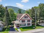 INVESTMENT PROPERTY or WEEKENDER REFUGE along the peaceful Schoharie Creek in the Village of Hunter! This traditional three-level home is a rare findâ€”solid, stately, and built to last. Meticulously maintained throughout the years, it offers timeless charm in a truly remarkable setting. Superb for entertaining, with sweeping mountain views that are sure to impress.Step inside to a spacious mudroom, the ideal catch-all for gear after a day of adventure. From here, enter the heart of the homeâ€”the kitchenâ€”featuring gleaming granite countertops, stainless steel appliances, and a cozy pellet stove. This open and inviting space is ideal for both cooking and conversation. Sip your morning coffee as you watch skiers carve down the backside of Hunter Mountain.This home offers no shortage of bedroomsâ€”five on the second floor plus one on the main level, each floor complete with a full bath for convenience. The true standout is the finished, heated attic, offering nearly 1, 000 square feet of versatile living space! Whether used as a private haven, a recreational area, or simply a place to unwind, it&rsquo;s the ultimate escape after a long day.Your guests will feel like they&rsquo;ve found their own private paradise with a dedicated lodging space. The open-concept design paired with rustic charm creates a warm and welcoming retreat, complete with its own kitchen area and full bath. Step outside to a private covered deck overlooking the creekâ€”the sweetest spot for dining and relaxation.Enjoy plenty of off-street parking, with additional spaces available out front. The property features a two-car garage beside the home, plus another in the back that doubles as a workshopâ€”great for projects or extra storage. Public water and sewer provide serviceability and peace of mind.This location can&rsquo;t be beat! Perfectly situated between Phoenicia and Windham, there&rsquo;s something to enjoy in every seasonâ€”hiking, skiing, biking, swimming, golfing, fishing, and festivals. At just 2.5 hours from NYC, plus a Trailways bus stop in town, you&rsquo;re absolutely connected while still immersed in the heart of the Catskills.