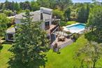 Waterfront Contemporary in the Village. Tucked away on a quiet cul-de-sac, this shingle-style contemporary offers both privacy and proximity to all the Hamptons have to offer. Just over a mile from Westhampton Beach&rsquo;s Main Street and with direct water access in the backyard, the four-bedroom, three-bath home is designed for effortless indoor-outdoor living. Every level features floor-to-ceiling windows that flood the interior with natural light and frame dramatic sunset views. Sliding doors extend to multiple decks, a pool and spa with a bluestone surround, and park-like grounds enhanced by mature specimen trees and bordered by a stream leading out to Moriches Bay. Inside, the main level features a sun-filled great room with vaulted ceilings, a wood-burning fireplace, and water views. There are two bedrooms on the ground floor, including one en-suite; a third bedroom with outdoor access is on the main level; and the upstairs primary suite features a private balcony. Additional highlights include a wine cellar and a detached bonus space, perfect for a home office, gym, or guest quarters. This waterfront property is a true resort-style retreat, close to shops and ocean beaches, perfect for both seasonal or year-round living. Welcome home!