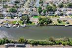 Experience waterfront living at its finest. This beautifully updated and spacious residence offers the perfect blend of luxury and leisure, designed for those who dream of a year-round retreat by the water. Nestled on a bucolic property with sweeping canal views and direct access to the Great South Bay, this home is truly a boaterâ€™s paradise. Step inside through the inviting entry foyer and into the elegant formal dining room, highlighted by a large bay window that fills the space with natural light. The grand, state-of-the-art kitchen has been fully renovated with top-tier appliances, designer cabinetry, sleek countertops, and a stunning backsplash, making it the heart of the home. The expansive den, with soaring ceilings and a wood-burning fireplace, offers the perfect setting for gatherings and entertaining. The main level is complete with a spacious laundry room and a convenient powder room. Upstairs, the primary suite serves as a private retreat, featuring a fully updated bath with a modern vanity and walk-in shower. Two additional bedrooms share a beautifully upgraded hall bathroom, providing comfort and style for family or guests. The exterior is just as impressive, with a professionally landscaped and fully fenced property designed for both beauty and privacy. The crown jewel of this residence is the two deeded waterfront lots, offering 80 feet of bulkhead with newly updated decking â€” the ultimate setting for boating, entertaining, or simply enjoying the tranquil water views. Perfectly positioned directly across from Tanner Park, this home provides an unmatched lifestyle â€” secluded and peaceful, yet just minutes from local dining, attractions, and major roadways. Situated south of Montauk Highway, it offers the rare combination of luxury, convenience, and exclusivity.