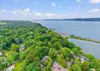Mid-Century Modern elegance meets cottage-core charm in this architecturally distinctive cedar home, tucked away in a serene enclave just off the Hudson River. Designed with timeless detail and expanded in 1985 by award-winning architect Don Reiman, the residence is filled with striking architectural momentsâ€”sunken living room with fireplace, soaring ceilings, walls of windows, and a stunning solarium that blurs the line between indoors and nature. Natural light pours through skylights and expansive windows, illuminating the open living and dining spaces. The inviting kitchen with granite counters and a cozy glass-wrapped breakfast nook opens seamlessly to a private bluestone patio, perfect for morning coffee or evening gatherings. Upstairs, a lounge with a wood-burning fireplace leads to a dramatic primary suite boasting vaulted ceilings, floor-to-ceiling windows with seasonal river views, a walk-in closet, and a marble bath with oversized whirlpool tub. The homeâ€™s natural landscaping, mature plantings, and perennial gardens create a peaceful, low-maintenance retreat with changing colors from spring wildflowers to brilliant fall foliage. Additional highlights include three fireplaces, Marvin and Andersen windows, a whole-house generator, energy-efficient updates, and freshly refinished spaces. A rare bonus: the detached garage has been fully converted into a finished studio with sound reduction â€”ideal as creative space, gym, or home office. With four bedrooms, three full baths, and exceptional indoor-outdoor flow, this property lives like a work of art. All just two minutes to Scarborough train station for an easy NYC commute, and minutes to Sleepy Hollow, Tarrytownâ€™s restaurants, and Hudson River parks.