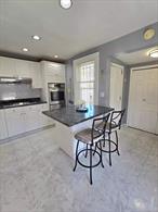Welcome to this beautifully updated three-bedroom, two-bathroom home, thoughtfully designed for comfort and versatility. The main level offers a sunlit living and dining rooms with sleek tile flooring and an elegant crystal chandelier- the perfect setting for gatherings. The modern kitchen shines with crisp white cabinetry, granite-style countertops, stainless steel appliances, and an impressive double pantry. Upstairs, the bedrooms are bright and airy, complemented by a fully renovated spa-like bathroom with a frameless glass shower, rainfall shower head, designer vanity, and a state-of-the-art smart mirror. The semi-finished lower level, complete with a second full bath, provides flexible space for guests, recreation, or additional living. Outdoor living is enhanced by a gated yard with custom stonework, ideal for entertaining, along with a detached garage for parking or a workshop. Additional upgrades include a seven-year-old roof with solar panels, keeping energy costs minimal. Truly move-in ready, this home balances modern luxury with everyday practicality.