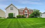 Nestled in sought-after Four Corners this stately brick-face Colonial blends comfort, style and convenience. Boasting five bedrooms and three full baths on a premium, level lot. The Grand two story entry flows into a Great room with vaulted ceilings, gas fireplace and a wall of windows. The gourmet Kitchen with large center island is well equipped. The elegant Living room and dining room feature hardwood floors, tray ceilings and custom moldings. Home office with built-ins, guest bathroom, and convenient laundry complete the main level. An expansive primary bedroom suite includes a spacious sitting room, tremendous walk-in closet, and a spa bathroom. The basement level features an additional bedroom and full bath along with a recreation room with many potential uses. The spacious three car garage has plenty of extra room for storage and the lush, level yard with stone patio could easily accommodate an in-ground pool. You will love the recently renovated 20K sq. ft. clubhouse and resort style amenities: outdoor pool, tennis courts, indoor and outdoor basketball courts, a 5-acre park, nature trails, 2 playgrounds, and a retail center. Something for everyone with indoor gym/fitness center, sauna, billiards room, Movie Theater and room for private events. Sought after muni water, sewer, gas heat; plus whole house generator and owned solar panels. Located just minutes from top-rated schools, shopping, and major commuter routes this property combines small town charm with big-time convenience!