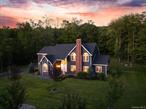 OVER THE RIVER & THROUGH THE WOODS - Set on nearly an acre of picturesque property in the highly sought-after South Orangetown School District with attractive taxes under $18K, 27 Valenza Lane offers the rare combination of space, serenity, & style, all just 30 minutes from NYC. Enveloped by the protected woodlands of Clausland Mountain & Blauvelt State Park, the property & community feels private & restorative, yet remains close to everything the Hudson Valley & nearby river town villages have to offer. The home itself, a striking colonial completely reimagined in 2021 by architect/owner, stands with timeless curb appeal: vibrant navy siding, crisp white trim, & a proud brick chimney rising above manicured landscaping. Almost 4, 000 SF of living space unfolds like chapters in a story of light & comfort, with a total of 5 bedrooms; 4 upstairs & 1 convenient bedroom suite on the main level. The foyer greets you with a dramatic spiral staircase, ceilings that soar, & a sense of openness that carries throughout. Natural sunlight floods the interior, creating a calm & soothing atmosphere. In the living room, a brick-accented fireplace glows softly, inviting both conversation & solitude. In the family room, another hearth anchors gatherings, its warmth echoing against vaulted ceilings. In the primary suite, w/ dramatic vaulted ceilings, a spa like bath, a third fireplace stands ready to lend its quiet light to the most private hours, turning winter evenings into something almost sacred. The kitchen is a symphony of craftsmanship & design, a complete renovation that left nothing to chance. Custom solid-wood cabinetry gleams in white, quartz counters extend seamlessly into a full backsplash, and an oversized island commands the room like a stage set for family & friends. A professional 6-burner range waits to be tested by ambitious meals & farmhouse sink glistens under natural light. All fixtures chosen for both performance & elegance. Throughout the home, every surface speaks of intention: herringbone porcelain tile guiding your entry, wide-plank floors lending warmth to the upper level, all upstairs bedrooms have ample walk-in closets outfitted w/ oak shelving, bathrooms reimagined as spa retreats with radiant-heated floors, frameless glass showers, & deep soaking tub in primary. Light itself becomes a design element through arched windows, mid-century pendants in foyer & dining room & Lutron smart switches that let you set the mood. A large basement allows for expansion. Step outside & the story continues: a Trex deck for morning coffee or starlit evenings, paver walkways, professional landscaping that frames the home in color. Beyond aesthetic beauty, this home has been fortified with care & precision, ensuring peace of mind for years to come. In 2021 new high-efficiency HVAC units installed & an upgraded drainage system designed to protect the grounds in all seasons. The exterior was meticulously refreshed - fascia boards, gutters, downspouts, window trim, & corner posts all replaced, while the chimney was repointed & capped with premium detail. Above it all, a new GAF architectural roof stands as both crown & safeguard. These structural upgrades, coupled with the home&rsquo;s immaculate presentation, make 27 Valenza Lane truly a turn-key residence. When you step beyond your own gates, the Hudson Valley waits. To the east the river town villages of Nyack & Piermont hum with life: boutiques, galleries, cafes, restaurants, the Edward Hopper House with its reverence for art, & the Piermont Pier stretching miles into the Hudson like a painter&rsquo;s brushstroke. To the west, the trails of Clausland Mountain Park & Blauvelt State Park lead you under cathedral trees, across stone ruins, & into landscapes where history and wilderness intermingle. More than a house and a community, 27 Valenza Lane is a retreat for those who value nature as much as luxury, where every detail has been reimagined, & every finish refined...