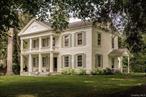 A fabulous example of early Hudson Valley architecture, this c1840 Greek Revival farmhouse sits on three rolling green acres of meadow and gardens. Old growth maples dot the landscape, the property is just 5m from the vibrant city of Hudson but a world away. Its stacked covered porches are framed by classic columns, and gorgeous six-over-six windows are lined with the homeâ€™s original shutters. Inside youâ€™ll find wonderfully high ceilings and wideboard plank floors, four bedrooms and three full baths. So many fabulous original details have been preserved, and so much charm added over the homeâ€™s long life. The kitchen is large and gracious, with a gas stove and fireplace. The living room has a fabulous onyx mantle and walks out to a private back yard. Youâ€™ll find a pergola draped with wisteria and a garden shed/studio perfect for projects or creative endeavors. Upstairs, four large bedrooms are all fabulously stylish, light filled and spacious. 24 Van Wyck is architecturally stunning & ideally located, minutes outside of Hudson, just 8m to Amtrak and 2h north of NYC.