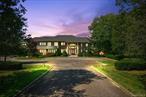 Set along a picturesque, tree-lined street, this stately brick colonial offers over 10, 000 square feet of refined living space, gracefully situated on more than four acres of impeccably landscaped grounds. With seven bedrooms, five full and two half baths, and soaring ceilings throughout, this estate blends timeless elegance with the ease and comfort of resort-style living.A grand two-story foyer welcomes you in, unfolding into a dramatic living room with soaring double-height windows that frame views of the expansive backyard. Two additional living areasâ€”a sophisticated sitting room and a spacious great room with a custom built-in barâ€”provide ample space for both entertaining and everyday living. The chefâ€™s eat-in kitchen features dual islands and opens to a generously sized formal dining room, perfect for hosting large gatherings.The main level also boasts a luxurious primary suite complete with dual walk-in closets, double private toilettes, a gas fireplace, and a private patio with tranquil views. A dedicated staircase from the suite leads to a custom second-floor study or den. Also on the main level: an additional en-suite bedroom, full laundry room, two half baths, and a wide central hallway.Upstairs, an open hallway overlooks the foyer, great room and living room. Five spacious bedroomsâ€”two with private en-suite baths and one with a shared bathâ€”each enjoy access to outdoor balcony space, abundant sunlight, and large closets. A second laundry room and a walk-up attic offer added convenience and functionality.The walk-out lower level is fully equipped for recreation and relaxation, featuring a vast great room, golf simulator room, gym with sauna, playroom, private office, guest suite, full bath with changing area, and generous storage.Outside, the grounds are designed for entertaining at any scale, with a heated pool and spa, full-size tennis court, and multiple terraces. A three-car attached garage completes the offering.Every inch of this remarkable home reflects the scale, sophistication, and lifestyle of a private country clubâ€”nestled in one of the North Shoreâ€™s most prestigious settings. Jericho School District.