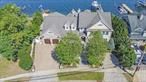 Welcome to your year-round beach house! Featured in House Magazine, this truly majestic 4, 844 sq ft Custom Built French Colonial-style home is situated on 140â€™ of private sandy beach that overlooks the Great South Bay. Stunning sunrises and sunsets with views of Fire Island Lighthouse in the distance. A 100â€™ pier and 16, 000 pound lift accommodates most any size boat. Bring your catch home and chat with your guests while you cook on the 42â€ stainless-steel Lynx grill and full outdoor kitchen under a pergola. Everything for entertaining is here-refrigerator, ice maker, industrial stainless sink and faucet and two outdoor bars, huge multi-level deck, gas fire pit and outdoor TV entertainment center. An ingound , heated saltwater gunite swimming pool with three waterfalls overspills from an irrigated flower garden. Enter inside to the custom gourmet kitchen with solid cherry cabinetry by Rutt with a sub-zero refrigerator, Wolf stove and oven, Thermadore convection oven, microwave and warming tray. The kitchen center Island is just off the main kitchen area with a copper tray ceiling. The formal living room and dining rooms feature coffered ceilings and wrap around a massive two-sided gas fireplace. The dining room includes custom refrigerated wine closets and a service area with a hammered copper wet bar and a beverage center and ice maker. The Great Room has a vaulted ceiling surrounded by windows, and topped outside with a copper-roofed cupola and weathervane. Continue entertaining indoors in the Billiard Room with a Brunswick pool table and direct access to the backyard fire pit area. Overnight guests have their own bedroom and a full bath and laundry room. A private office is near the stained-glass front door with matching sidelights and transom. Head upstairs to the full Library with one of two huge balconies that overlook the bay. The Primary bedroom suite includes a sitting room with a small kitchen to prepare your morning coffee and itâ€™s own laundry room. Glass pocket-doors lead to the huge primary bedroom featuring vaulted ceilings, its own balcony, and a walk-in â€˜his & hersâ€™ closet. The primary bathroom is designed as a spa with a two person double steam shower, air tub and water closet. Three full additional bedrooms and a bathroom are on the second floor. The curved bridal staircase takes you to the third floor to a complete gym with multiple exercise machines, and an additional office overlooking the bay. Brazilian Cherry Hardwood is featured throughout the entire house. Last, but not least is the front of this regal home with a bluestone porch and porch swing, a semi-circular driveway with pavers and lighted pillars with room for five cars in addition to the two-car heated garage with Mahogany Garage Doors. Fully landscaped with LED landscape lighting around the entire property. Four- zone heat, five-zone A/C, five-zone Sonos Sound System, security system with cameras and full house automation. Attic and extensive storage areas. This house was elevated by Historical House Lifters in 2013.