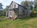 Early 1800s Farmhouse is awaiting your vision to restore back to its original charm. A completely blank slate retaining some natural original details; wide board floors, mantles, moldings and hardware. Set back off a quiet country road and a knoll surrounded by mature shrubbery, bordered by farmland and a whimsical forest. Perfect opportunity to restore or replace. Columbia County Taxes and the Red Hook School District.
