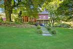 Nestled amidst a vibrant embrace of mature trees and lush plantings, discover this beautifully restored and expanded 1788 Farmhouse. A true gem; offering almost 2200 sq ft of living space over multiple levels. The charming facade, with its warm blend of red siding, cream trim and classic dormer windows, hints at the character and comfort within. This home is a haven for both grand gatherings and intimate moments, one you simply cannot miss. Follow the inviting stone walkway, framed by blossoming gardens, to a private slate patio where you&rsquo;re greeted by a picturesque open green vista. The landscaping, rich with a variety of plants and flowers, creates a sense of natural beauty and seclusion but with a rare expansive lawn. Step inside from the covered porch into an updated, welcoming kitchen, complete with a generous island, abundant custom cabinetry, a dining area, and a cozy wood-burning stove. Seamlessly connected, the kitchen flows into short hallway and then a sprawling living room with built-in speakers, multiple windows and soaring vaulted ceilings - perfect for entertaining or quiet evenings. A few steps up from the dining area lead to an open living/recreation space boasting beamed ceilings, a convenient powder room, and a tucked-away office nook. Ascend a few more steps to discover the primary bedroom, featuring built-in shelving, a walk-in closet, a laundry area, and an ensuite bathroom - a true retreat. At the opposite end of the open living space, stairs lead to two sizable and bright bedrooms with vaulted ceilings, a shared gathering area, a full bathroom, and a windowed 12x9 room that could easily be transformed into an office or a custom walk-in closet. Outside, imagine relaxing on the patio with an open view of the manicured lawn, perfect for enjoying your own piece of paradise. Additionally, this sale includes a separate 7.1-acre parcel across the road, complete with a 2-car garage, a picturesque pond with a small dock, and abundant woods, ensuring unparalleled privacy and tranquility. Please note, lot line revision in process- this will result in the current parcel to be approx 1.5 acres, for a total of approx 8.6 acres included in the sale.