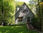 Set on 1.8 wooded acres in the quaint hamlet of Stanfordville, 106 Tick Tock offers an ideal blend of charm and privacy in a convenient location. Surrounded by mature trees, the home feels wonderfully secluded. Its appeal is enhanced by an old stone wall and an upper lawn with Adirondack chairs, ideal for relaxing outdoors.The main level of the home features an open-concept layout and 10-foot ceilings, giving the house a lofty, spacious feeling. A sweet living room and dining area lead to the back deck, perched high among the surrounding trees. A thoughtfully designed kitchen with cherry cabinetry offers ample counter space and storage. The first floor is completed by a full bathroom and a bedroom, which could also serve as a home office. Upstairs, there are two additional bedrooms, each with views of the surrounding forest, as well as another full bathroom with a tub. High ceilings in the basement add to the home&rsquo;s ease and practicality, with ample dry storage space and a drive-in one-car garage.Outdoors, the back deck overlooks the lawn and woodlands beyond, offering a serene backdrop for entertaining, gardening, or simply enjoying the peace of nature. Whether you&rsquo;re making use of the plentiful seating areas outside or strolling the lawns, the home&rsquo;s setting captures a perfect balance of solitude and convenience.Located in a quiet residential neighborhood in Stanfordville, the property is close to the towns of Millbrook, Pine Plains, and Rhinebeck, with easy access to dining and shopping at well-known destinations like Stissing House and Hammertown. Just a short drive brings you to farm stands, hiking trails, and many other Hudson Valley attractions, making this an ideal retreat for weekends or a full-time home alike.