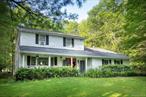 Wonderful, Private Location!Tucked away on 2.2 acres of peaceful, park-like grounds, this inviting home offers the perfect blend of privacy, beauty and convenience. A long gravel driveway winds past tall trees and green space, opening to your own hidden havenâ€”set well back from the road, yet just minutes to Woodstock and Saugerties, with their vibrant shops, restaurants, and culture.The approach is unforgettable: a wide rocking-chair front porch stretches across the front of the house, welcoming slow mornings, sunset conversations, and everything in between. The sun-drenched front yard offers endless potentialâ€”from garden parties and outdoor games (especially for your furry friends ball chasing delight!) to quiet, contemplative afternoons under the sky.Inside, the home offers over 2, 000+ square feet of well-planned living space, filled with natural light and warm, easy elegance. Plenty of room for visiting family and friends, with 3 bedrooms and 2 full baths upstairs and wonderful places to be both all together and to enjoy their own quiet time, that include a gorgeous skylit sun room, a family room for cozy evenings by the fireplace, a sitting room and a formal dining room. The generous eat-in kitchen which opens to a large entertaining deckâ€”is perfect for summer BBQs or al fresco dinners under the stars. From there, step down into the backyard framed by stone walls and old-growth trees for added seclusion.The attached garage provides both convenience and practicality, with ample storage and direct entry into the home. Every element of the property has been thoughtfully considered, from the layout that encourages connection with nature, to the placement of the home that ensures a sense of peaceful removeâ€”without sacrificing access to daily essentials.A large sized shed with AC and power has been used by the current owner as a recording studio, and the unfinished full basement with it high ceilings, abundant storage space and dance floor, are both open to be whatever suits your needs or your imagination desires...Whether youâ€™re seeking a full-time residence or a weekend refuge, this is a home where tranquility meets possibility.Walking distance to the Woodstock Day school, less than 10 minutes to the town of Woodstock and 1 hour and 45 minutes to Manhattan
