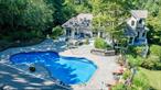 Experience North Shore Living at Its Finest. This stunning residence blends elegance, comfort, and resort-style amenities. This truly spectacular backyard is a private oasis with a heated pool, hot tub, custom pavers, adorned with fieldstone walls & professional landscaping, a built-in BBQ area, and a pool house equipped with a full kitchen, bathroom, CAC, heat, and covered patio. Stone steps lead to a parklike side yard with an additional garage beneath the pool house. Inside, the grand foyer opens to a living room with soaring ceilings, a dramatic two-sided quartzite fireplace, and walls of glass with transom windows framing backyard views. The primary suite offers deck access, two walk-in closets, and a spa-inspired bath with Jacuzzi tub, oversized shower, dual sinks, and radiant heat. The gourmet kitchen features a quartzite island, Sub-Zero refrigerator, Thermador oven, wine/beverage cooler, walk-in pantry, and breakfast nook. Off the formal dining room is a sun-filled four-season room that leads directly to the backyard deck, perfect for entertaining or relaxing with a view of the pool and gardens. The main level also includes a spacious laundry room, powder room with marble sink, and a two-and-a-half-car garage with direct access. Upstairs, a loft overlooks the living room, accompanied by oversized bedrooms, vaulted ceilings, custom built-ins, and sun-drenched adjoining rooms with skylights. The lower level offers a finished recreational area plus storage, utilities, and a wine room. Additional upgrades include: New: 50 year architectural roof, pool liner & heater, central vacuum, hot water heater, french drain system. Set in the desirable Shoreham-Wading River Central School District, this home offers the perfect balance of small-town charm, natural beauty, and modern convenience located just minutes from Long Island Sound beaches and perfectly situated at the gateway to North Fork wineries. Enjoy the Wildwood State Park nearby with hiking, biking, camping, and proximity to golf courses, and local farms. Wading River has it all, making this home not just a residence, but a lifestyle!