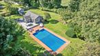 Privately situated & set back from the road, this charming East Hampton cottage features over 1/2 an acre of cleared, luscious property. The 2-bedorom, 1-bath pied-a-terre is close to all, just 100 yards from the famed Round Swamp Farm and 2 miles from East Hampton&rsquo;s Main Street. Inside, the kitchen is well-appointed with granite countertops, a GE natural gas range, and a full suite of Frigidaire appliances, including dishwasher & stackable washer and dryer. The living room and one of the two bedrooms open directly to the back deck, blending indoor-outdoor living. Hardwood floors and shiplap walls create a welcoming, coastal aesthetic, while recent upgrades-including custom window treatments (2024) and new Andersen windows (2025)-enhance comfort and efficiency. Central air, forced hot air heating, and natural gas utilities provide reliable year-round comfort. Step outside to a private backyard oasis, complete with a 20x40 heated pool, outdoor shower with hot and cold water, and a spacious, wrap around wood deck-perfect for entertaining. The cleared property is fully fenced, irrigated, and includes a permitted -750SF potting shed. With ultra-low annual taxes of just $3, 870.44 & years of successful rental history, this property offers exceptional value rarely found in East Hampton.