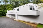 Discover 140 Old Saw Mill River Rd, Hawthorne, NY 10532, a 15, 788-square-foot, one-and-partial-two-story ultra-modern steel and masonry building designed by acclaimed architect Renato Severino. Originally envisioned as a premier commercial film studio and headquarters, this versatile property now includes approximately 5, 000 square feet repurposed as a high-end food and beverage hub, ideal for innovative businesses in culinary arts, media, or exotic automotive. The headquarters features a spacious open-plan office area, private offices with private terraces, a modern conference room, and a dedicated dining space, fostering collaboration and productivity. The main studio, with its soaring 24-foot column-free ceilings and roll-up garage door, offers unmatched flexibility for creative or technical operations. Additional spaces include three warehouses (6, 620 SF, 2, 590 SF, and 820 SF) and a 5, 970 SF second-floor office, complemented by amenities such as HVAC, a security system, and natural gas heating for optimal functionality.