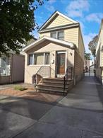 Welcome to this beautifully maintained Ozone Park colonial home, offering a versatile layout and modern comforts. The main level features a front foyer for organized entryway storage, spacious formal living and dining rooms with gleaming brand-new wood floors, and oversized windows for plenty of natural light. The sunny eat-in kitchen is designed with ample cabinetry and room for casual dining. Upstairs, youâ€™ll find three comfortable bedrooms and a full bathroom, providing plenty of space for family living. The entire house is modernized with split units for air conditioning and as a secondary source of heating, with multiple compressors for power. The fully finished basement with a separate outside entrance presents an ideal opportunity for extended family living or a private apartment setup, complete with its own second kitchen and full bathroom. An attic provides additional storage space, with room for a pull down hallway stair. This home features a private driveway, detached one-car garage, and a generous backyard patioâ€”perfect for entertaining, gardening, or simply relaxing. The homeâ€™s charming front brick facade and detailed brickwork steps add curb appeal, while the driveway and garage offer valuable convenience.With three bedrooms, two full baths, modern split units, a flexible lower-level, attic storage, private driveway, and garage, this home blends comfort, functionality, and opportunity all in one.