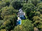 Located within the Cold Spring Harbor School District, this custom-built modern Tudor where timeless architecture meets todayâ€™s design. A dramatic grand foyer with soaring ceilings and floor-to-ceiling windows sets the tone for the homeâ€™s elegant style. The open-concept great room impresses with vaulted ceilings, exposed beams, and wide-plank engineered wood floors, seamlessly connecting indoor and outdoor living. At the center, the chefâ€™s kitchen showcases an oversized island, custom cabinetry, quartz countertops, and top-of-the-line Wolf and Sub-Zero appliances. The main level is thoughtfully designed with two spacious bedrooms and 1.5 baths, providing comfort and flexibility for guests, home office, or multi-generational living. An attached two-car garage adds everyday convenience. The primary suite offers a serene retreat upstairs, with tray ceilings, oversized windows, and a spa-inspired bathroom featuring dual vanities, a glass-enclosed shower, and contemporary finishes. The finished walkout basement expands the homeâ€™s living space, with a full bathroom, highlighted by a custom-built bar with rich wood tones, modern shelving, and stylish seating. This area flows into a lounge/media room with direct access to the pool and backyard. Outdoor living is extraordinary, offering three distinct experiences in one private setting: a resort-style pool with sleek stone patios and lounge areas, play zone seamlessly integrated into the landscape, and a covered entertainment deck with dining space and hot tub for year-round enjoyment. An elevated stone patio with a built-in gas firepit completes the pictureâ€”the perfect setting for entertaining or quiet evenings. Blending classic Tudor charm with modern sophistication, this one-of-a-kind residence offers privacy, luxury, and convenience in the sought-after Cold Spring Harbor community.