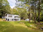 Welcome to Fawn House, a modern rustic retreat in evolving Accord, celebrated for its rural tranquility and sophisticated amenities. Sitting quietly on over 28 acres across two parcels, this property offers privacy, peace, and an effortless connection to nature. Walls of glass and a Scandinavian-inspired design fill the 3, 055-square-foot residence with natural light, creating a warm and welcoming atmosphere. The first floor is designed for gathering, with an open kitchen, dining, and living area at its center. A den with a wood stove provides a cozy retreat in cooler months, while a full bath, laundry room, and storage room add comfort and convenience. Upstairs, a vaulted great room opens to a sunroom with another wood stove, perfect for watching the seasons unfold. The spacious primary suite is complemented by two additional bedrooms, a study, and two full baths, balancing private space with areas for work or guests.Decks and bluestone patios extend the living space outdoors, ideal for entertaining or unwinding among the quiet beauty of the landscape. The property consists of two parcels: The home sits on 4.89 acres with a shed and an oversized garage that offers abundant storage and flexible possibilities. The adjoining 23.5-acre parcel remains undeveloped, preserving a serene backdrop while offering potential for future expansion or long-term conservation.Though tucked away, the location is minutes from farm-to-table favorites like Westwind Orchard, Accord Market, Saunderskill Farm and Ravenwood, along with the memberâ€™s club, spa, and restaurant at Inness. The nearby towns of Stone Ridge, High Falls, and New Paltz offer additional shops and dining, while Minnewaska State Park and Mohonk Preserve are close at hand for endless outdoor adventure. This rare Hudson Valley offering combines modern design, expansive acreage, and a prime location, making it an exceptional retreat or full-time residence.
