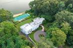 Experience the ultimate in waterfront living with this extraordinary 9, 000+ sq. ft. estate set on two sweeping acres with 200 feet of private shoreline in Oyster Bay. Designed for both grand entertaining and everyday comfort, the residence offers 5 bedrooms, 6.5 baths, and 4 fireplaces, all supported by modern essentials including a full-house generator and security system.Step inside the dramatic entry foyer where light and space unfold into expansive living areas with floor-to-ceiling windows framing panoramic water views. The main level is highlighted by a sophisticated living room, formal dining room, and a versatile lounge/meeting space. A library with its own bath provides a perfect retreat or guest option. The chefâ€™s kitchen impresses with granite counters, custom cabinetry, professional appliances including three ovens and two dishwashers, and an adjoining laundry/mudroom. A spectacular 1, 600 sq. ft. great room with a wet bar and wood-burning fireplace anchors the first floor.Upstairs, three ensuite bedrooms each open to private balconies overlooking the water. The primary suite is a true sanctuary featuring a fireplace, spa bath with dual vanities, and an oversized walk-in dressing closet. Outdoor living is elevated with more than 1, 800 sq. ft. of wraparound decking, a tennis court, gazebo, and direct water access for kayaking, jet skiing, and more.The lower level extends the lifestyle with an indoor pool and hot tub, an entertainment space with wet bar, a full guest suite with private entrance, abundant storage, and a 4+ car garage. With meticulous craftsmanship and unparalleled amenities inside and out, this residence is not just a homeâ€”itâ€™s a private waterfront resort.