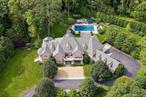 This impressive cedar and stone Colonial is elegantly positioned on an expansive 5+ acre, private resort-caliber property bordering protected land. Premium materials and custom finishes throughout. The interiors boast soaring ceilings, bespoke details, open floorplan and grand windows framing picturesque views of the manicured grounds. The elegant double-height entry foyer opens to formal rooms and segues to the heart of the home. Two offices and a game room with bar are set apart from the main rooms for privacy. An impressive two story family room segues to the gourmet kitchen and breakfast room. Retreat to the sumptuous primary bedroom suite on the upper level, complete with professionally designed bath offering radiant heated floors, an expansive double steam shower, and a striking stainless-steel bathtub. Completing this level are four ensuite bedrooms, an upper level family room, laundry and stairs to the attic. The walk-out lower level provides an additional full bath with a large rec room. The backyard is a true oasis, featuring an inviting pool with spa, fire pit, state-of-the-art outdoor kitchen with built-in refrigeration, and a putting green. Entertain in style beneath the rear covered terrace equipped with an advanced music system and ambient outdoor lighting. Additional highlights include a four-car heated garage, generator, and indoor and outdoor speakers. Located within the coveted Chappaqua school district, minutes to the train station, shopping and dining. Just 45 minutes to New York City. Epitomizing upscale living at its finest. Your weekend getaway, everyday.