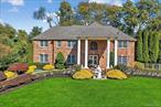 Elegant Georgian Colonial Residence in prestigious Camelot Estates Community in New City. A majestic double-height foyer with marble flooring and an elegant chandelier sets the tone for this grand home. The main level features formal living and dining rooms, a private study with custom-built-ins, and an open-concept gourmet kitchen with a center island, marble countertops, and a breakfast area that flows seamlessly into the family room, which boasts a dramatic two-story ceiling and a gas fireplace framed in brick. A guest suite with a full bath, powder room, spacious laundry, and a secondary kitchen, ideal for outdoor entertaining, completes this floor. Upstairs, the luxurious primary suite features a spa-like master bathroom with serene views of the backyard and pool, a spacious walk-in closet, and a cozy sitting area with built-in bookshelves, perfect for reading or relaxing. Three additional well-appointed bedrooms, each with generously sized closets, share a full bath. The finished walk-out lower level offers versatile living and entertaining areas, including a recreation room, an additional bedroom with a closet, a full bath, a mechanical room, and interior access to the three-car attached garage. Designed for both elegance and leisure, the exterior features a covered porte-cochere, a classic brick facade, circular and side driveways accommodating up to 16 vehicles, and beautifully landscaped grounds with full irrigation and a sprinkler system. The backyard oasis includes a heated pool (36 x 18 ft, 4â€“8.5 ft deep) with a diving board and dual spa seating areas. Modern comforts include a two-zone HVAC system, a 200-amp electrical panel, an ADT security system installed, a high-efficiency water heater, a central vacuum, and a water softener. This extraordinary home offers the perfect blend of grandeur, functionality, and tranquility, just moments from country clubs, upscale shopping, major parkways, and top-rated schools.