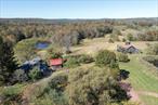 Once the home and studio space of an internationally renowned pop artist and print maker, this 92 acre property with three ponds, a vineyard, and a vast expanse of rolling hills begs to be explored. The original farmhouse was built in 1880 and has been lovingly maintained with plenty of original charm preserved. Two barns, three tiny houses and a green house complete this offering - each bringing something special to this unique compound.Enter The Farmhouse through the foyer to discover an open chefâ€™s kitchen with a top-of-the-line 7 burner stove with convection oven, modern stainless steel appliances, and wine refrigerator â€“ a dream for entertaining. The formal dining room overlooks a cozy sunken living area featuring a wood-burning fireplace and a wall of windows to create a warm and elegant setting. Upstairs youâ€™ll find the large primary suite, a private sanctuary for rest and relaxation, complete with a soaking tub and walk-in shower. Two additional bedrooms and a full bathroom offer plenty of room for family and guests. An additional room on the first floor can be used as an office or another bedroom, and a laundry room, pantry, and half bath add to the homeâ€™s day-to-day functionality.Enjoy sunsets from the rock-paved sitting area outside the farmhouse overlooking one of the ponds, the greenhouse, and vineyard. The larger barn boasts impressively high ceilings, open space, and ton of natural light. Currently set up as an incredible art studio, this building could easily house a myriad of hopes and dreams. Upstairs offers an additional sitting area and outdoor deck with even more possibilities for finishing for guest overflow or entertaining space. Climb the ladder to the crowâ€™s nest to discover stunning 360-degree views of the property and surrounding vistas. A smaller barn currently offers extra storage, and even more potential for expansion.Three Estonian Iglu tiny homes - each able to accommodate up to 4 people - encircle one of the propertyâ€™s ponds and are already running seamlessly as vacation rentals. Two wood-fired Iglu saunas and a hot tub make this relaxing retreat enjoyable year-round.The expansive Shire property offers a world of possibilities from transforming into an event space or wedding venue, a private compound with space for everyone, or multi-faceted horse and agricultural property. Schedule a private tour to experience the beauty and history of The Shire â€“ a rare gem that blends artistic legacy with natural splendor.This special property is conveniently close to Jeffersonvilleâ€™s bustling main street with it&rsquo;s excellent restaurants and shopping, and a great seasonal farmerâ€™s market. Within 10-15 minutes you will find the fun river towns that dot the Delaware like Callicoon and Narrowsburg, and youâ€™re just a hop, skip, and jump away from Kenoza Hall. Approximately 2 hours to NYC.