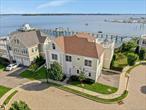 This luxury waterfront home on the Long Island Sound epitomizes elegance and sophistication, offering unparrelled views and a unique living experience. Expansive terraces enhance the residence, perfectly capturing the serene beauty of the water. The spacious 33-foot living room is designed for relaxation and entertainment, featuring a gas fireplace, custom built-ins, and three floor-to-ceiling French doors leading out to a terrace ideal for sipping coffee while watching the sunrise on the LI Sound. The gourmet kitchen is a culinary haven, equipped with GE Profile stainless steel appliances, white maple wood cabinets, and Caesarstone countertops. A dining area adjacent to the kitchen offers breathtaking water views, creating a delightful setting for meals. The primary suite serves as a luxurious retreat with access to the terrace, custom closets, and an en-suite bath adorned with Carrera marble accents. In addition, the home includes a large second bedroom with an en-suite marble bath and ample closet space. The upper level boasts a generous living area complete with a wet bar and access to a 500 square foot terrace, ideal for entertaining guests. This level also features a versatile third bedroom or large office space with a custom walk-in closet, a full bath, and extensive storage options. Throughout the home, attention to detail is apparent, with features such as beautiful hardwood floors, Andersen windows and doors, and high ceilings that blend style with comfort. Additional conveniences include spacious walk-in closets, a one-car attached garage, and central air conditioning for year-round comfort. Located within a private gated community, residents enjoy resort-style amenities including a clubhouse with a fitness center and a heated in-ground swimming pool. Resort-style living at its finest!
