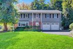 This 4-bedroom, 2.5-bath Colonial offers over 2, 655 square feet of living space on a quiet, mid-block setting. The main floor features a spacious living room, a formal dining room, a family room with a wood-burning fireplace, and eat-in kitchen with access to the backyard deck.Upstairs, the second floor includes four bedrooms: a primary suite with his and her walk-in closet, dressing room and private bath, plus three additional bedrooms - two with hardwood floors and one with its own walk-in closet, along with a full hallway bath.Additional features include Andersen windows, 2-zone heating, in-ground sprinklers, a full basement, and a 2 car garage. Recent updates include a updated roof (2018), upgraded electrical (2016), new oil burner (2023), and new garage doors (2025).The backyard offers mature plantings and a relaxing deck area, creating a comfortable outdoor retreat. With its highly desirable location just moments from the village, train, and village elementary school, this home offers endless potential to customize and make it your own.