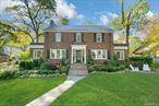 This classic brick center-hall Colonial seamlessly blends timeless architecture with modern comfort and style. Ideally located just .5 miles from the Larchmont train station, bustling town, restaurants, and the Saturday farmers market, it offers the best of village living. Leave your car in the oversized two-car garage and enjoy easy access to schools, parks, and Manor Beach. Sunlight pours in through new Andersen windows, enhancing the warmth and character found throughout. A gracious foyer opens to a large living room with gas, marble fireplace and built-ins, while a charming adjacent sunroom with original tile floors offers flexible use. The formal dining room with custom wallpaper leads to a bright breakfast area and a beautifully updated kitchen featuring skylights, all-new stainless-steel appliances, generous granite countertops, and new wine fridge and ice machine. A Dutch door from the breakfast area opens to the fully fenced backyardâ€”perfect for pets and play. The glass-enclosed family room, with radiant-heated floors and additional skylight, opens to two Zuri decks, creating a seamless flow for everyday living and entertaining. The updated powder room also features radiant-heated floors. Upstairs, the serene primary suite includes a private terrace, walk-in closet, and ensuite bath. Two additional bedrooms, an updated hall bath and laundry, complete the second floor. The third floor offers 2 additional bedrooms-flexible space ideal for guests, an au pair, or a home office. Thoughtful details such as refreshed lighting, custom window treatments, and new landscaping by Zavaglia enhance the homeâ€™s inviting appeal. Additional highlights include an extensive water management system around the perimeter, a beautifully maintained slate roof, and a fully fenced yard. Flooded with natural light and filled with craftsmanship, 19 Huguenot Drive combines charm, functionality, and convenienceâ€”an exceptional home in the heart of Larchmont.