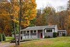 Set back from the road on 8 private acres, this turnkey home offers privacy, comfort, and a well maintained, peaceful retreat. Featuring renovated kitchen and bathrooms, all new windows and French doors, new gutters, a gas fireplace, and additional upgrades throughout, this home has been thoughtfully improved with quality updates inside and out. A legal three bedroom currently used as a two-bedroom, it includes two and a half baths, an open kitchen and dining area with a large island, Bosch appliances, and a breakfast bar. The living room features a gas fireplace and opens to a back patio for easy indoor-outdoor living. The lower level provides flexible space with an extra room, den, and bar area featuring a wood-burning stove. French doors lead outdoors, just a short distance from the above ground pool with a custom tigerwood surround. Additional features include a detached two-car garage and a fenced side yard, ideal for pets. Trails through the wooded property connect directly to the Whitlock Preserve, offering miles of scenic hiking right from your backyard. Located just minutes from the Taconic State Parkway, 10 to 15 minutes from Millbrook and Pine Plains, and 30 minutes from Rhinebeck, this property is perfect as a full-time residence or a peaceful country retreat.