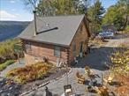 A one-of-a-kind hand-built home has come to market in charming Barryville NY with spectacular views of the Delaware River and the Poconos from its perch high in the Catskills. Affectionately known as The Hippie House, 129 Hallock Road in Barryville NY is a boho chic chalet-style house with detached workshop/artist&rsquo;s studio surrounded by 13 acres of wooded land, blue sky, south-facing endless views with all-day sunshine and fresh breezes that remind you of how private and peaceful life can be.Painstakingly built from scratch (including a winding hillside drive up from Hallock Road) in 2010, The Hippie House is more than a home, but a vision created by artisans who value privacy and beauty along with a deep appreciation for arts, crafts and quality. Set on a level plot at the top of 13 acres, The Hippie House has parking for many cars between the home and the studio along with a firepit and outdoor lounge. The 350 sf workshop/art studio is windowed on four sides for light and summertime ventilation, but also houses a wood-burning stove for the colder months and is finished with hand-hewn pine siding.The craftsmanship continues in the custom three level 1, 200 sf log cabin built in the chalet style with a pitched roof and windowed on four sides. Enter to the foyer and immediately you will sense the light and airiness that is central to this home. To the right is a walk-in storage room and to the left is a large corner bedroom with high ceilings, a ceiling fan, closet and a Jack-and-Jill full bathroom to the living room. Between the entry and the living room sits the spacious but adorable open kitchen finished with custom cabinetry in a beautiful woodsy hue, full-size stainless steel appliances, a wildlife window and a copper sink whose patina blends seamlessly with the cabinetry and open shelving evoking a sense of Mendocino, Malibu or Maine. But the showstopper is the 20&rsquo; high living/dining room with its wall of windows to the Delaware River and Pocono Mountains and the four seasons of wonder they provide. The living room centers on a large stone fireplace that easily heats the lower floor of the house. Huge windowed doors lead to the wooden deck bringing the outdoors in and where you will have a front row view of swaying pines, bees, butterflies, hawks and eagles on the wing and nary a sound but the wind in the trees.The upper floor is an open loft separated by an Adirondack staircase into two equal rooms that can be used as bedrooms, offices, dens or libraries with views to the hills. There is also a charming half bath (easily convertible to full) with an octagonal window view. Below the great room is a full finished basement that opens up a world of possibilities including the addition of another bedroom or family room plus massive storage space and mechanicals that are currently housed. The basement opens with glass doors to another flat area which begs to be finished as a wooden deck with sunken hot tub.Privacy, serenity, beauty and hand-crafted artisanship: 129 Hallock Road is a truly special place and one that must be seen to be believed. Please make an appointment today to see this beautiful home and studio. Will not last.