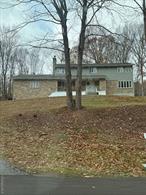 Situated on 1.43 acres, this home features a front porch, new recessed lighting, hardwood floors throughout and an abundance of natural light. Cozy up in the family room next to the brand new pellet stove insert complete with a renovated bathroom or spend time entertaining in the kitchen with stone countertops and a large adjacent dining room and living room. The primary bedroom features 2 walk in closets, a dressing area, a walk out balcony and an attached full bathroom. There are endless possibilities for the large finished basement that contains a walk out to a large 2 car garage ideal for a work space or storage. This home is a perfect place to add your special touches and contains central air, a new hot water heater, water softener and updated plumbing. This home is also located in a desired neighborhood and is conveniently located to route 55, the Taconic state parkway, metro north to NYC, shopping, rail trail, and more.